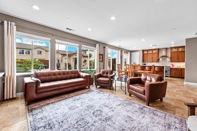 living area featuring recessed lighting, visible vents, and baseboards