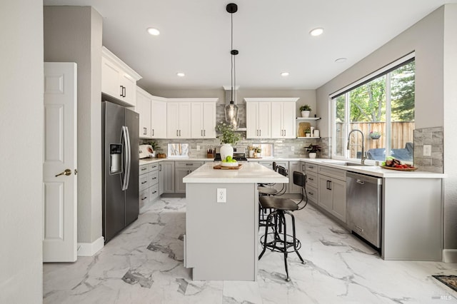 603 Canyon Oak Ct, Vacaville, CA 95688 - kitchen with appliances with stainless steel finishes, wall chimney range hood, a breakfast bar area, backsplash, and a center island