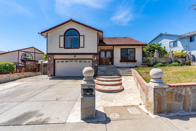 view of front facade with concrete driveway, an attached garage, fence, and a front yard