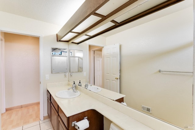 bathroom featuring vanity, baseboards, tile patterned floors, and visible vents