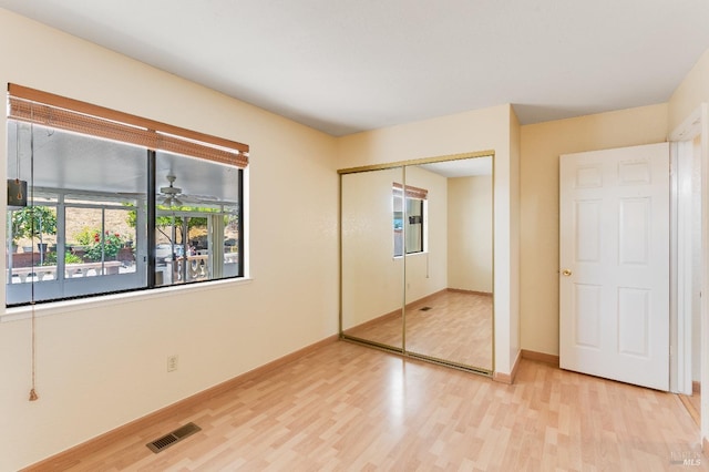 unfurnished bedroom with visible vents, baseboards, a closet, and light wood-type flooring