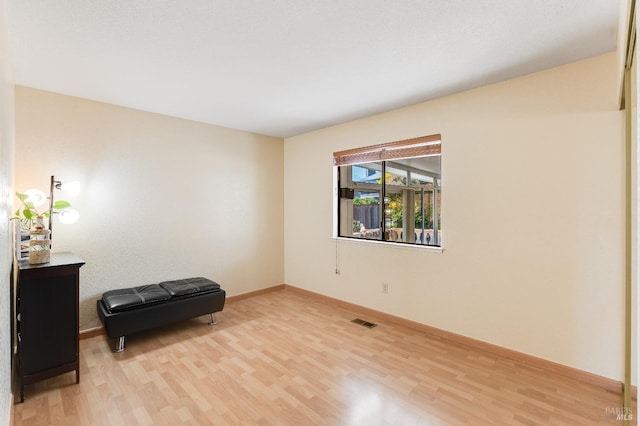 living area featuring baseboards, visible vents, and light wood-style flooring