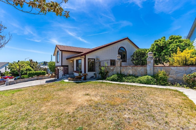 view of front of house with a garage, fence private yard, driveway, and a front yard