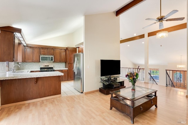 kitchen with a peninsula, appliances with stainless steel finishes, high vaulted ceiling, and ceiling fan
