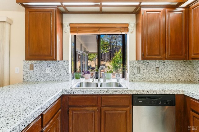 kitchen featuring a sink, backsplash, brown cabinets, and dishwasher
