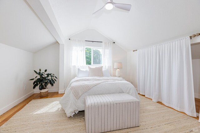 bedroom with baseboards, vaulted ceiling, wood finished floors, and a ceiling fan