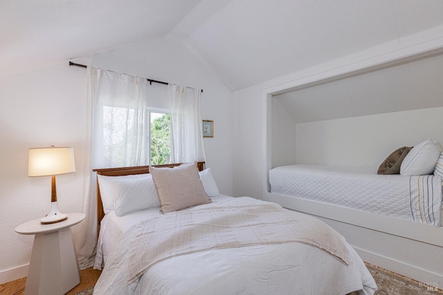 bedroom with lofted ceiling and wood finished floors