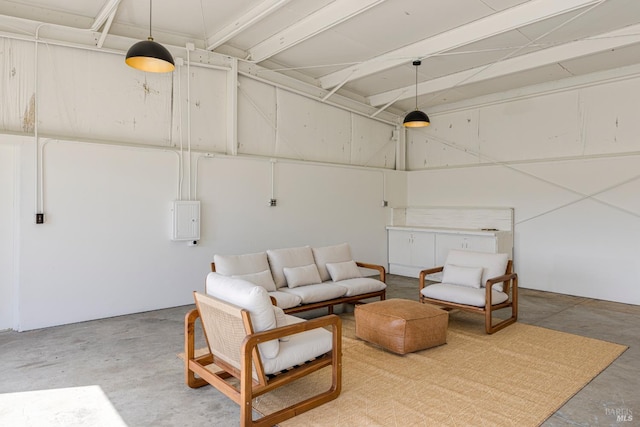 interior space with unfinished concrete floors and electric panel