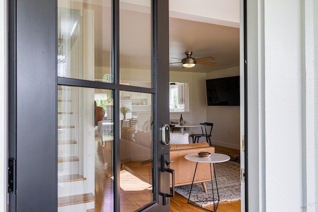 entryway featuring wood finished floors, baseboards, and ceiling fan