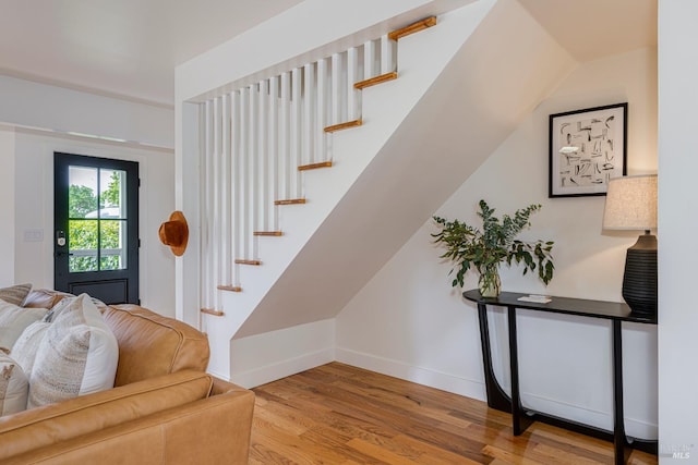 stairway with wood finished floors and baseboards