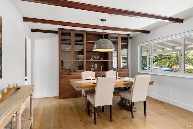 dining room with baseboards, light wood-type flooring, beamed ceiling, and visible vents