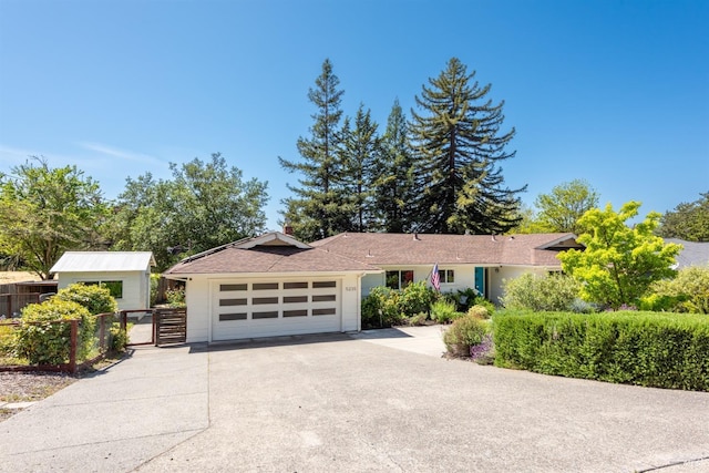 ranch-style house with driveway, a gate, and fence