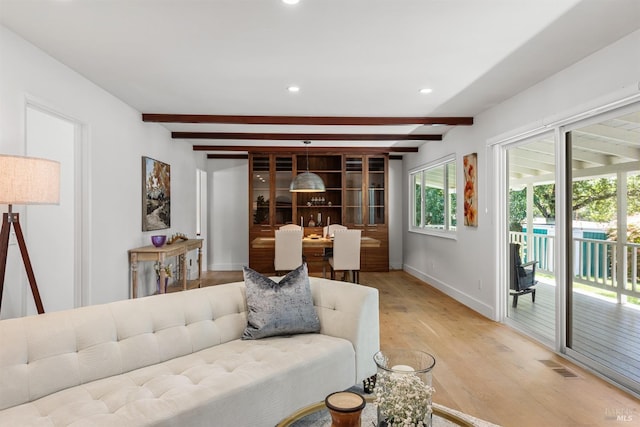 living room with light wood-style floors, visible vents, baseboards, beam ceiling, and recessed lighting