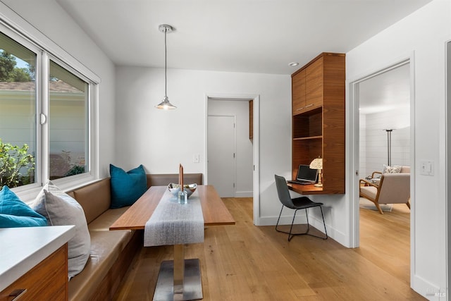 dining area with light wood-type flooring, breakfast area, and baseboards