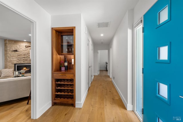 hall with visible vents, recessed lighting, light wood finished floors, and baseboards