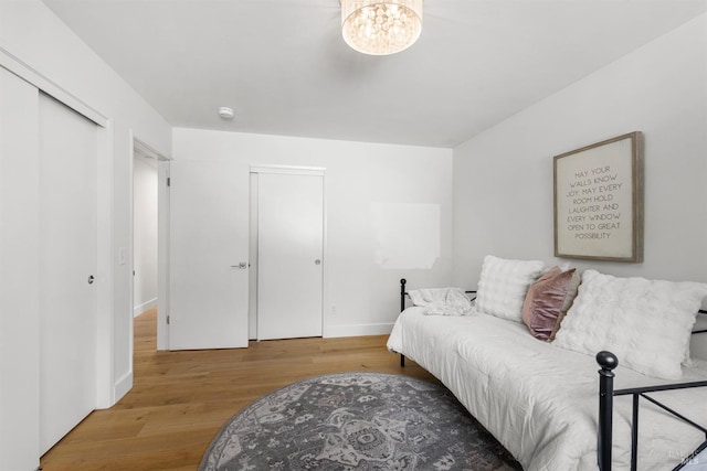 living area featuring wood finished floors, a chandelier, and baseboards