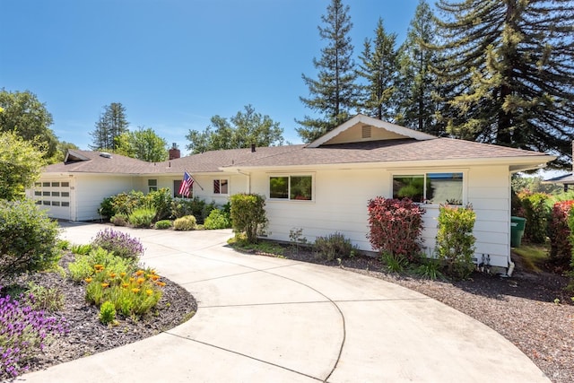 single story home with roof with shingles, driveway, and an attached garage