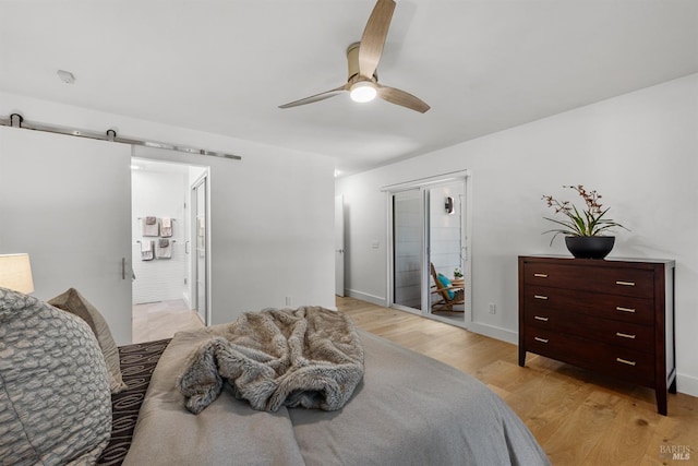 bedroom featuring baseboards, a barn door, ceiling fan, and light wood finished floors