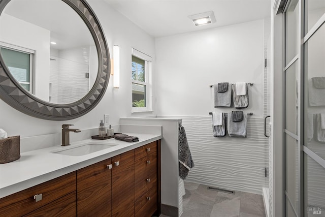 full bathroom featuring a stall shower, visible vents, and vanity