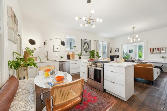 kitchen with white cabinets, appliances with stainless steel finishes, a sink, and modern cabinets