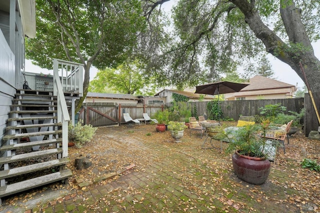 view of yard with a fenced backyard and stairway