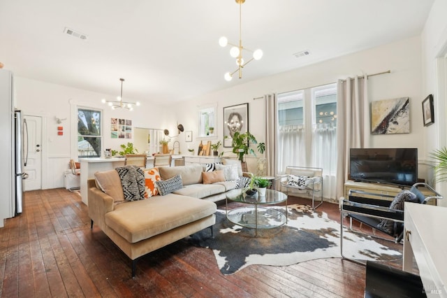 living area with a chandelier, visible vents, and hardwood / wood-style floors