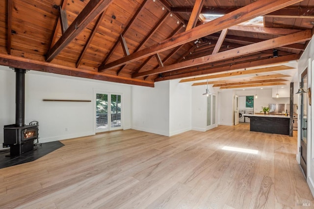 unfurnished living room featuring wood ceiling, lofted ceiling with beams, baseboards, and light wood-type flooring