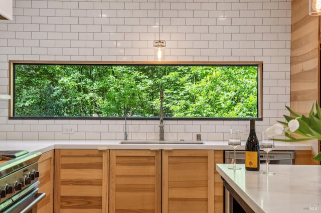 kitchen with backsplash, a sink, stove, and light countertops