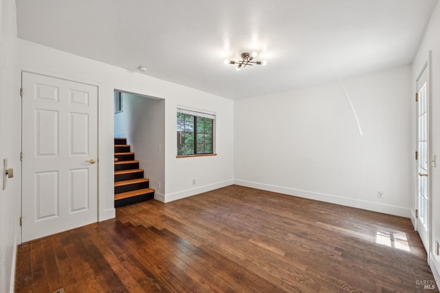 interior space featuring baseboards, dark wood-type flooring, and stairway