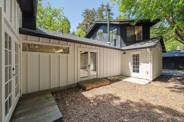 back of house with board and batten siding and french doors