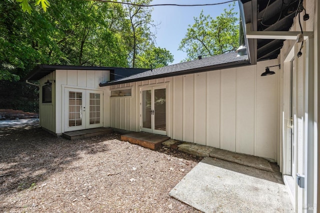 back of property with board and batten siding, french doors, and a shingled roof
