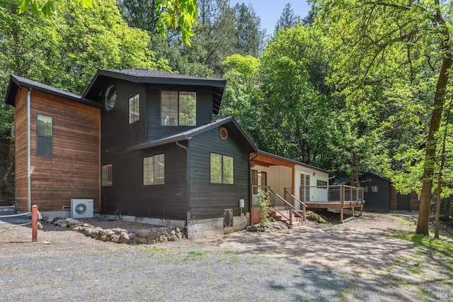 rustic home with a wooden deck and ac unit