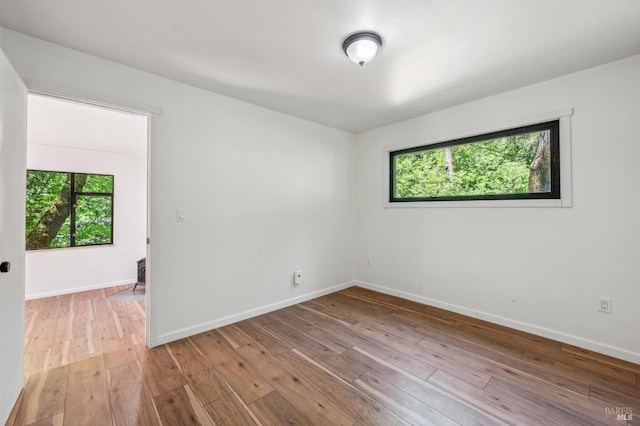 empty room featuring baseboards and light wood-style floors