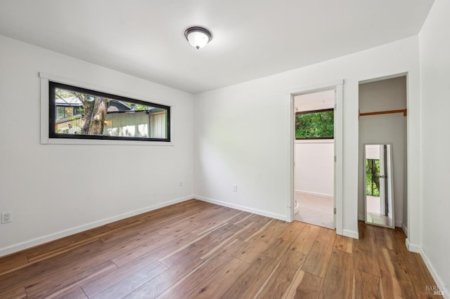 unfurnished bedroom with baseboards and light wood-type flooring