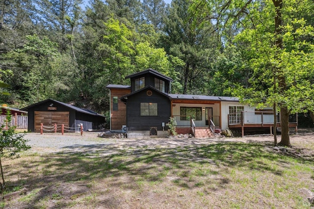 back of property with a porch, an outdoor structure, and a garage