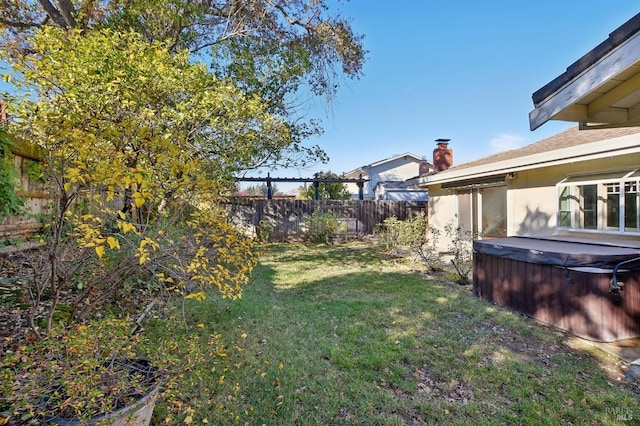 view of yard with a fenced backyard and a hot tub