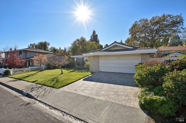 ranch-style home featuring brick siding, fence, driveway, a front yard, and an attached garage