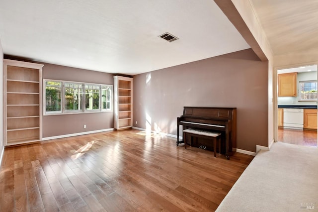 unfurnished room with visible vents, wood finished floors, and baseboards
