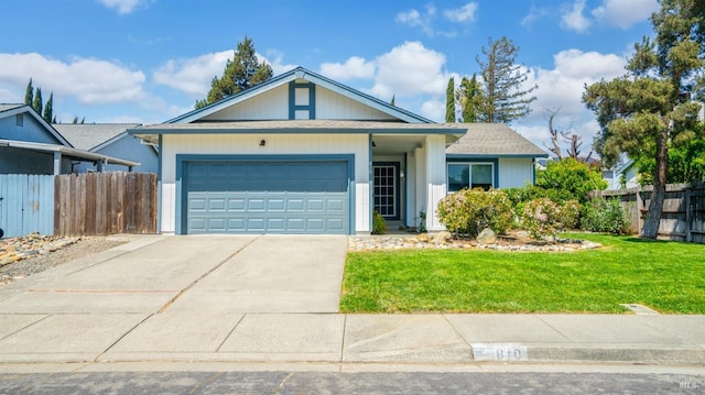 single story home with a garage, a front lawn, concrete driveway, and fence