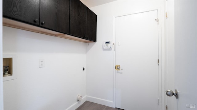 clothes washing area featuring wood finished floors, hookup for a washing machine, hookup for an electric dryer, cabinet space, and baseboards