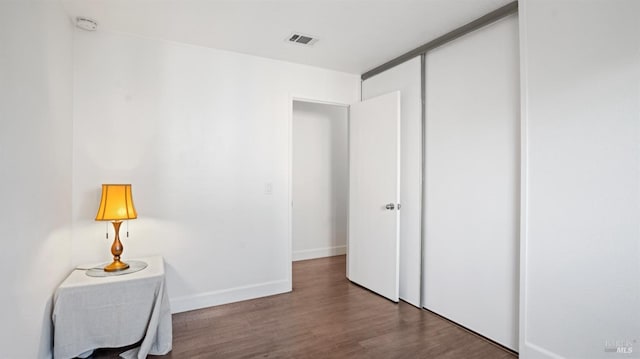 interior space featuring visible vents, baseboards, and wood finished floors