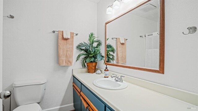 bathroom featuring visible vents, baseboards, vanity, and toilet