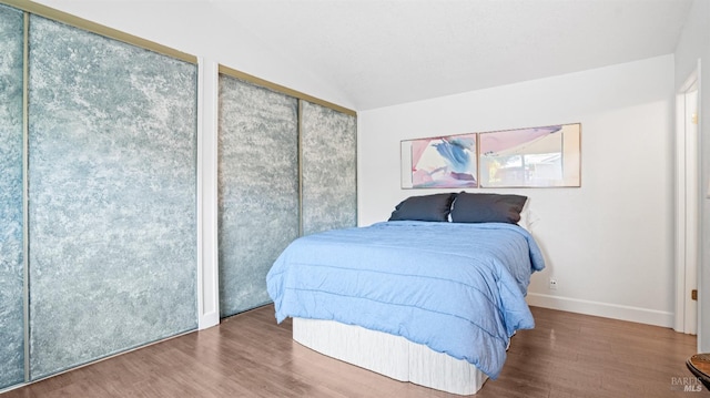 bedroom featuring vaulted ceiling, wood finished floors, and baseboards