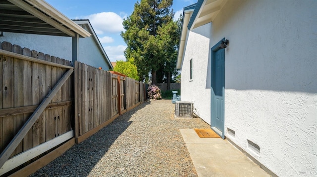 view of home's exterior featuring central AC unit, stucco siding, and fence
