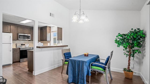 dining area with baseboards, a notable chandelier, wood finished floors, and visible vents
