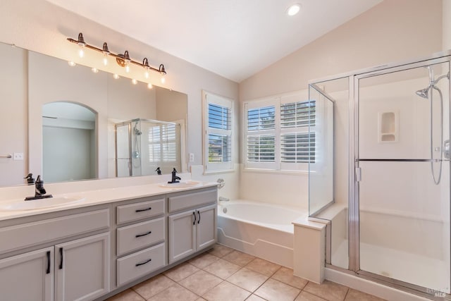 bathroom featuring a bath, vaulted ceiling, a sink, and a stall shower
