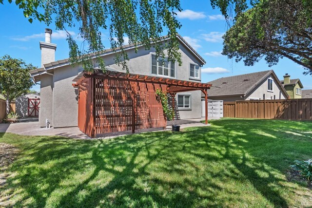 back of house with a chimney, a pergola, a fenced backyard, a yard, and stucco siding