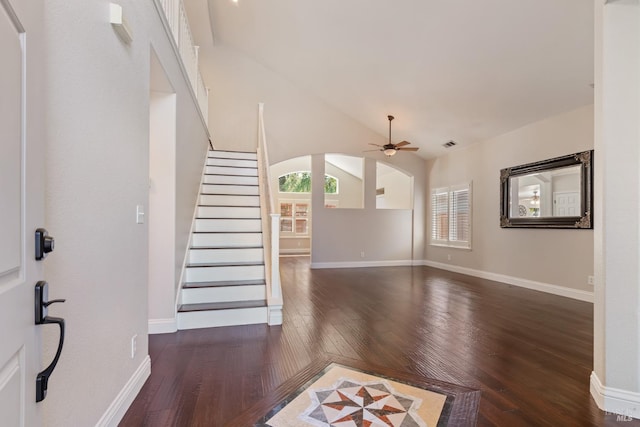 entryway featuring stairway, a ceiling fan, hardwood / wood-style flooring, arched walkways, and baseboards