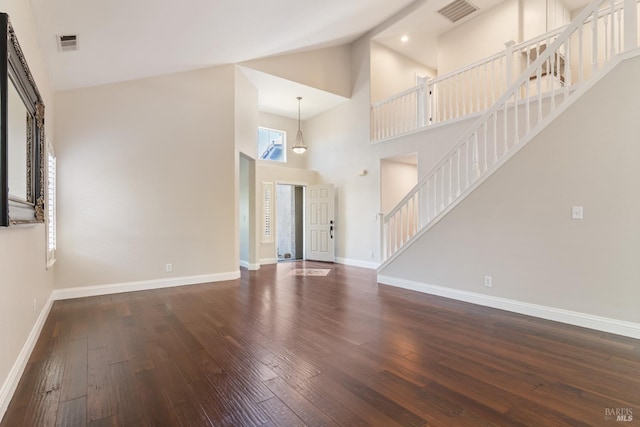 unfurnished living room featuring wood-type flooring, stairway, and visible vents