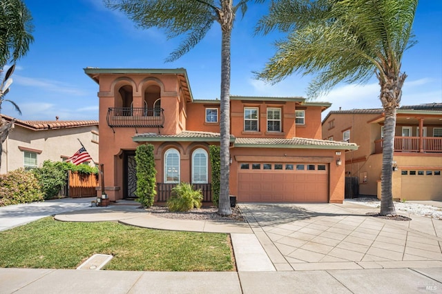 view of front of home featuring driveway, a garage, stucco siding, and a balcony